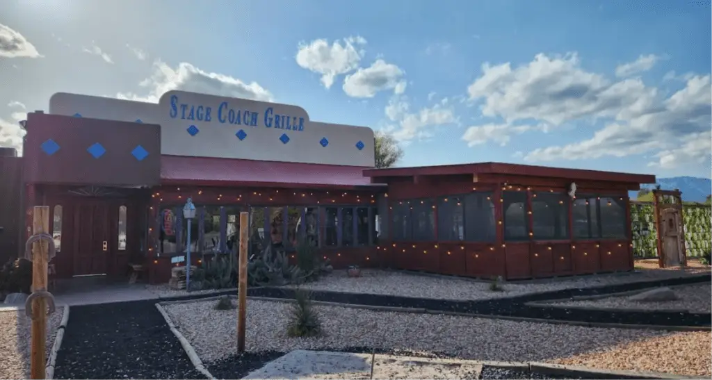 Stage Coach Grille restaurant exterior with rustic wooden siding and desert landscaping.