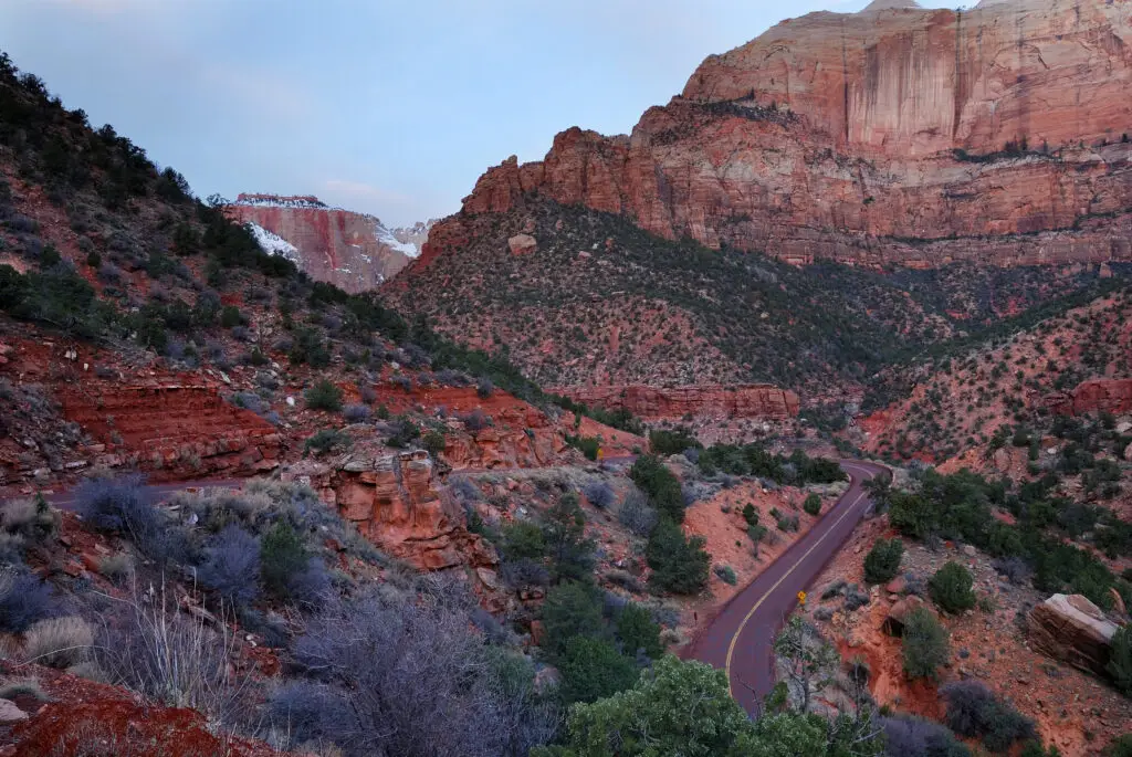 Scenic road winding through Zion National Park's red rock canyon landscape in Southern Utah.